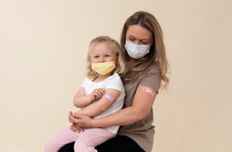 Mamá realiza la vacunación a su hija